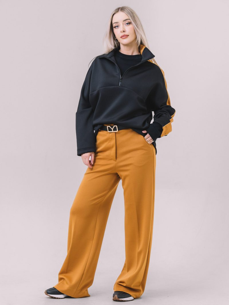 Model wearing the Freya Wide-Leg Knit Pants in camel paired with the Freya Half-Zip Jumper in black.